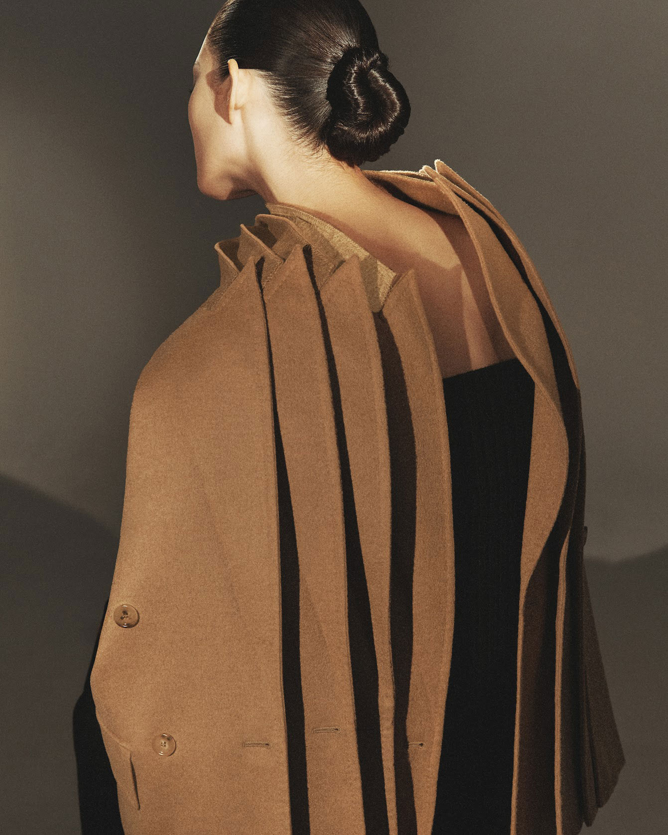 Model with sartorial detail of several Max Mara Olimpia Jackets in camel colour on the shoulders.